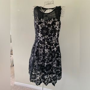 Black lace overlay dress. White satin underneath. Knee length. Sweetheart neck